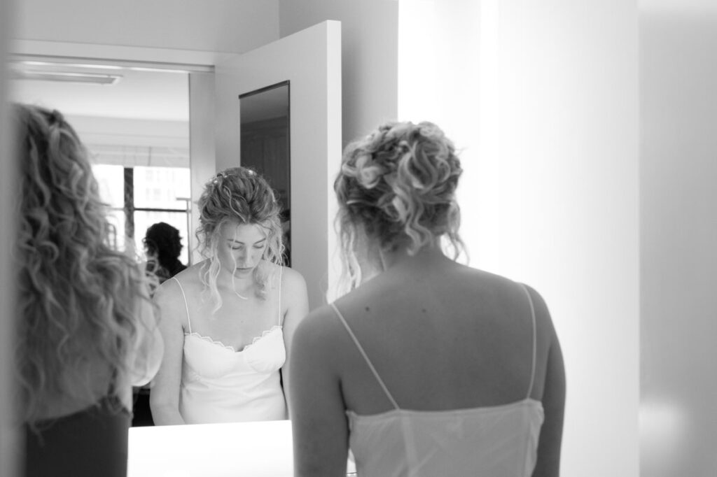 black and white photo of brides reflection getting ready
